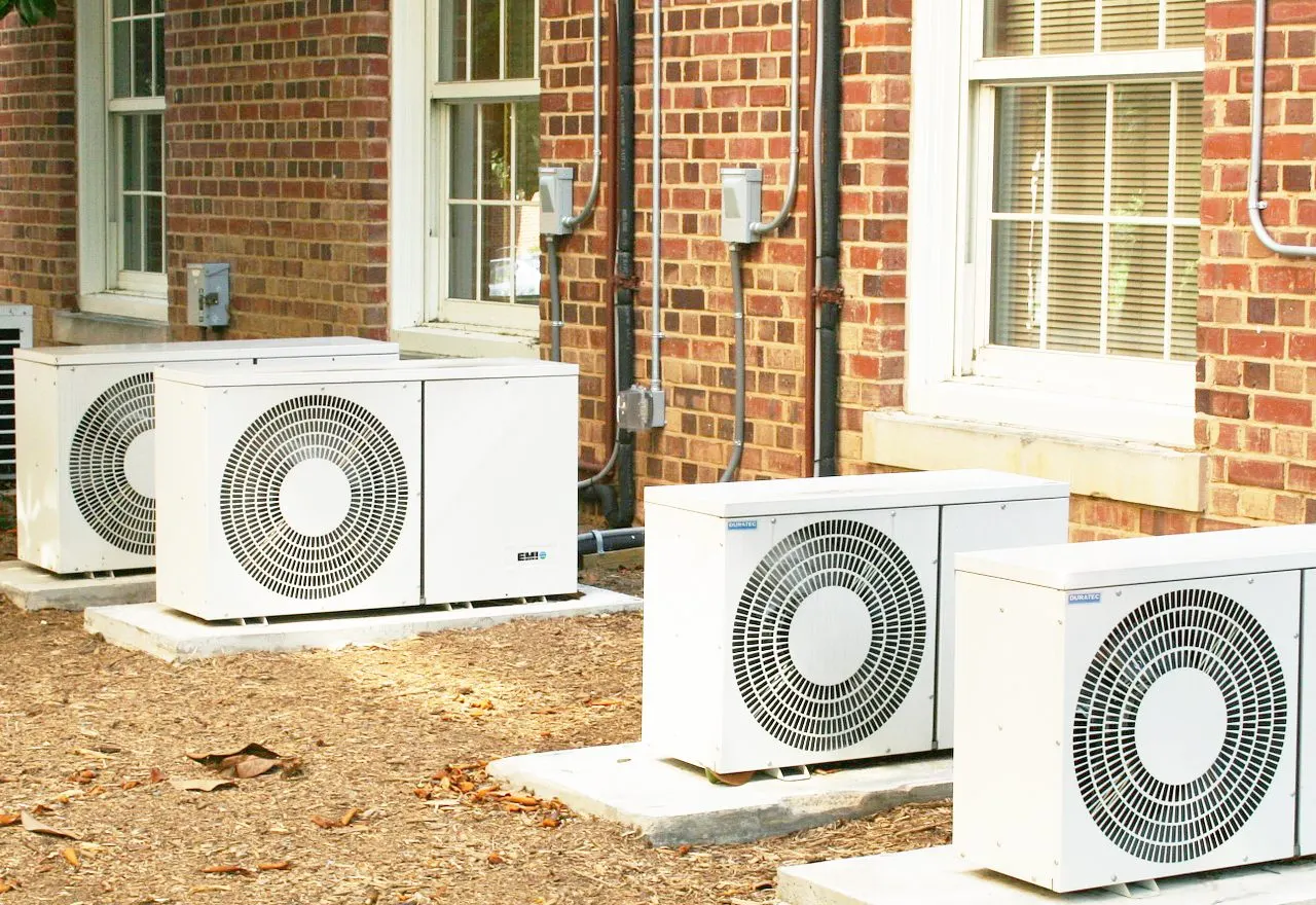 Outdoor air conditioning condensers beside a brick building