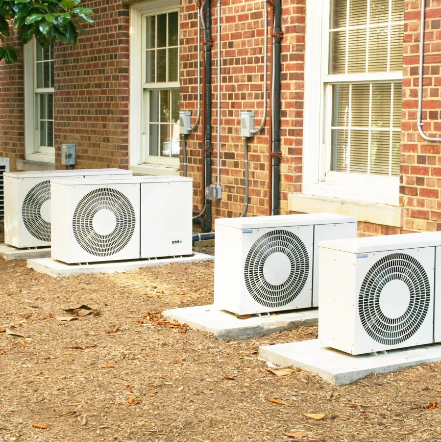 A row of condensers beside a brick building